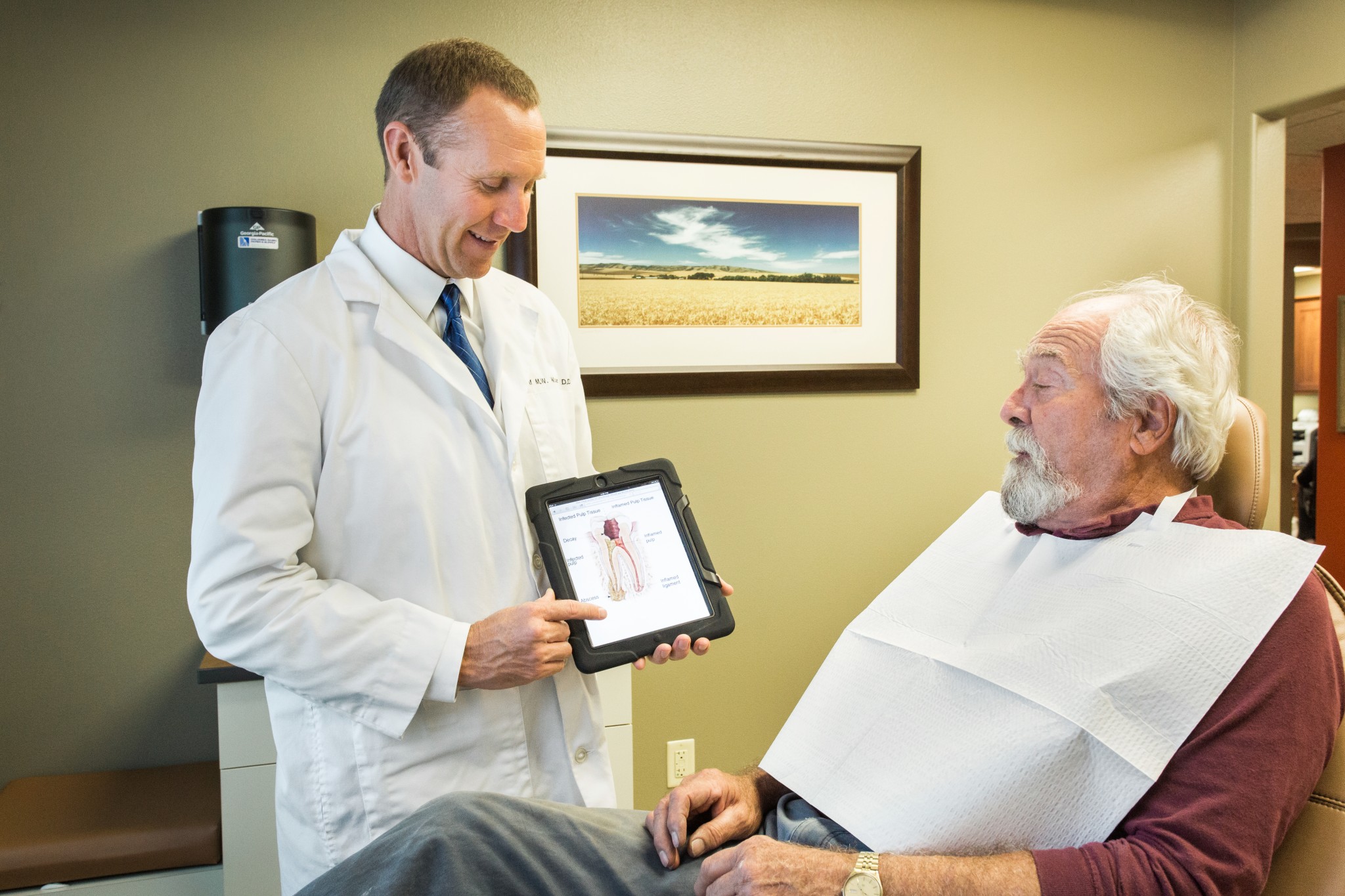 Board Certified Endodontis Rolf Wuerch educates a patient using a tablet